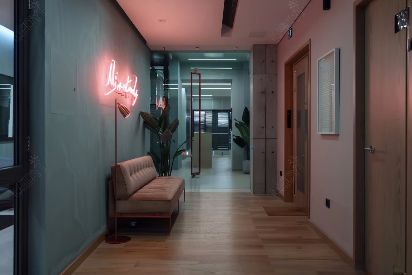 Modern office hallway with neon sign and seating area.
