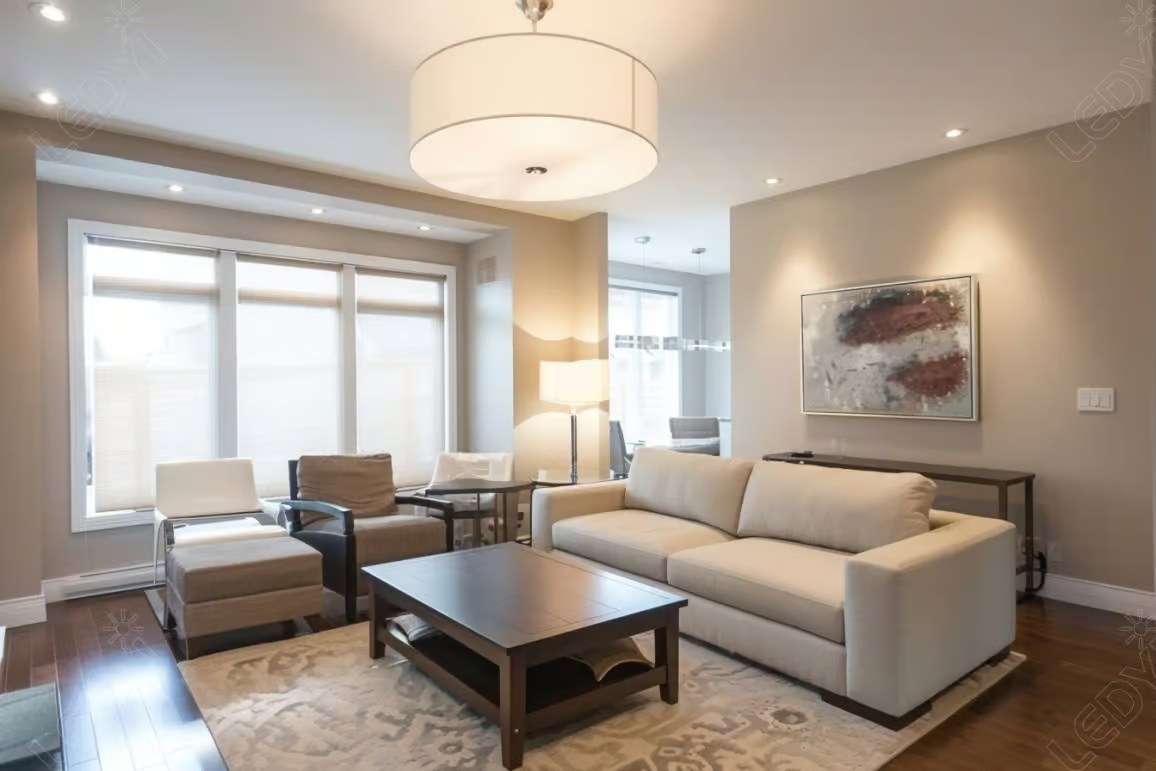 Modern living room with large windows and cozy furniture.