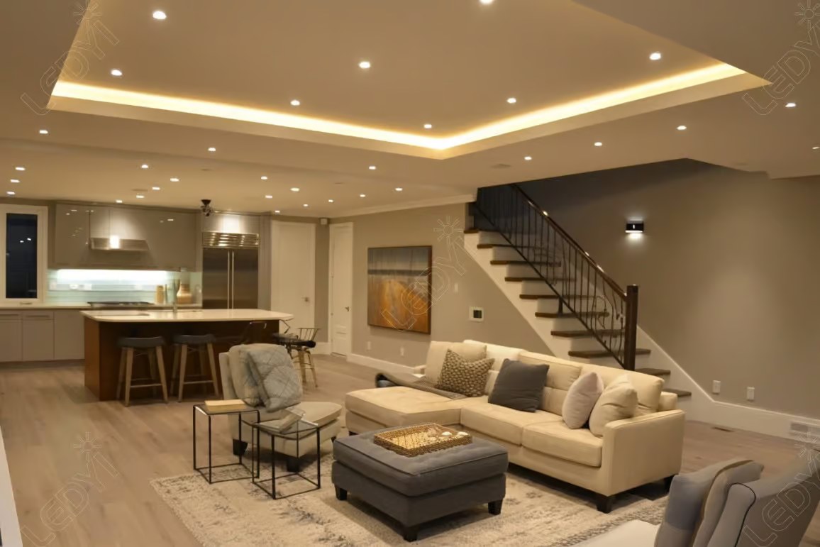 Modern open-concept living room and kitchen with recessed lighting.