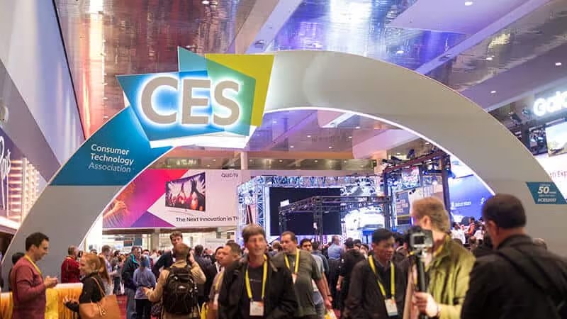 Crowd at CES technology expo entrance arch.